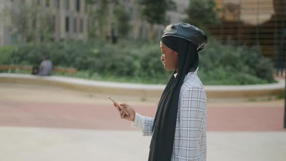 Muslim Woman Using Smartphone on Street alt