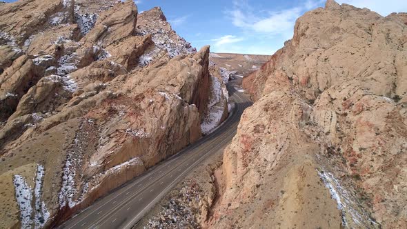 Flying backwards over road cutting into canyon gorge alt