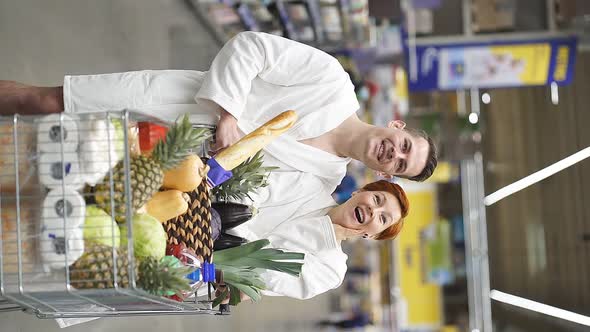 Young Couple Family Emotionally React on Discounts in Grocery Store in Bathrobe alt