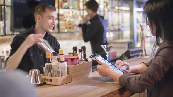 Women with Gadgets at Bar alt