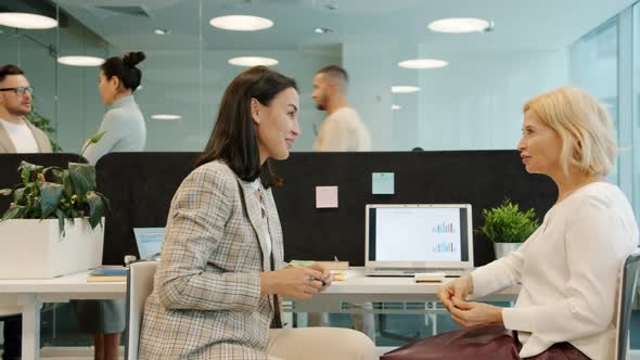 Happy Ladies Colleagues Talking and Laughing Working in Shared Workspace alt
