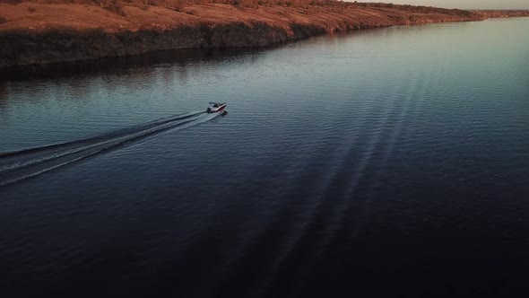  Motor Boat Floating on the River at Sunset