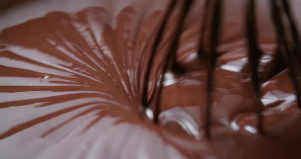 Closeup Chocolatier Mixing Melted Liquid Chocolate with Steel Whisk alt