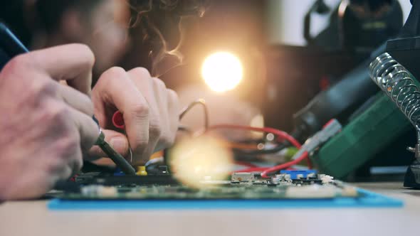Repairman's Hands While Soldering a Circuit in a Close Up alt