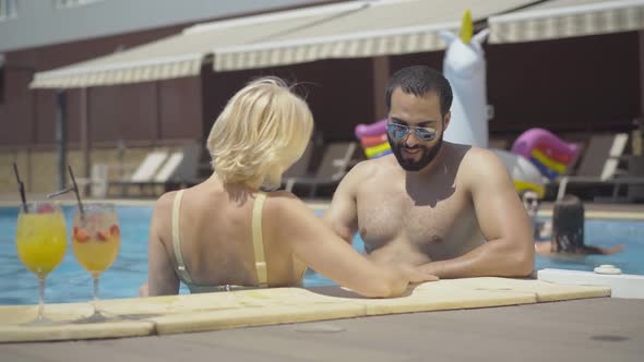 Handsome Young Middle Eastern Man in Sunglasses Flirting with Gorgeous Blond Caucasian Woman in alt