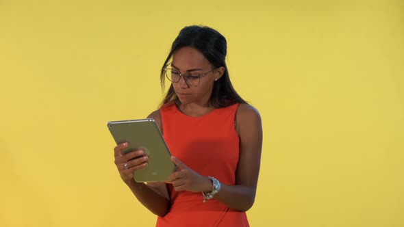 Black Business Woman in Dress and Eyeglasses Analysing Something on Tablet alt