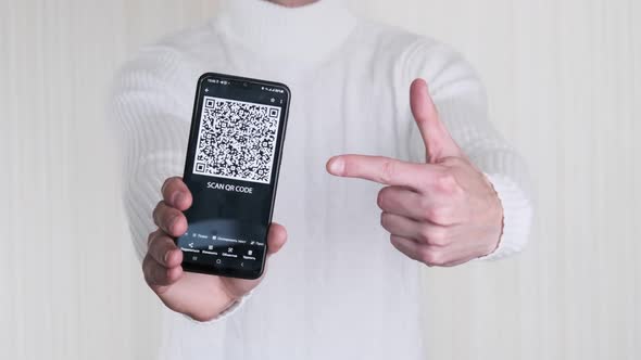Male Hand Shows QR Code on Smartphone on White Background alt
