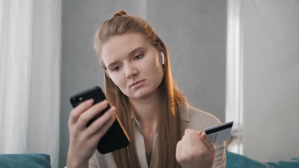 Smiling Young Woman Customer Holding Credit Card and Smartphone.