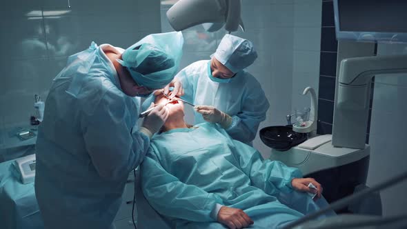 Dentist during a dental intervention with a patient. Dental clinic concept. alt