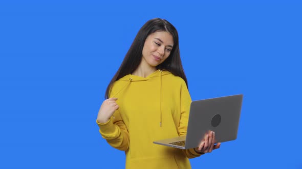 Portrait of Pretty Brunette Talking for Video Chat Using Laptop and Rejoice alt