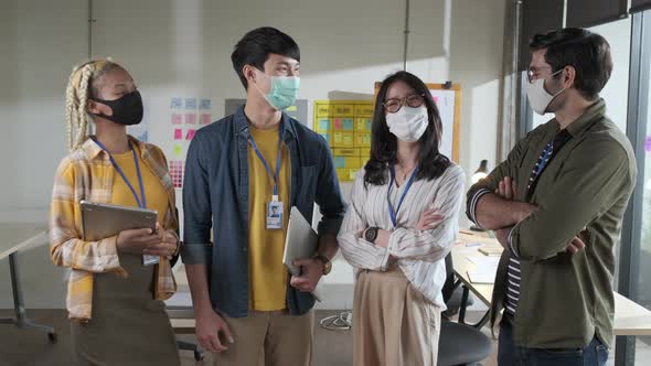 Young female creative with face mask for protective and prevention covid-19 portrait in office. alt