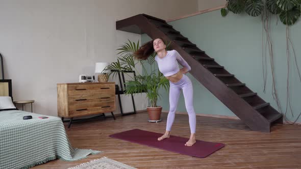 a Young Woman Doing Gymnastics at Home in a Tight Lilac Suit alt