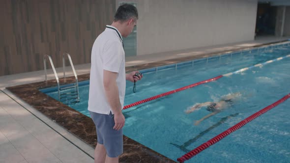 Slowmo of Coach Showing Thumbs Up to Swimmer during Practice alt