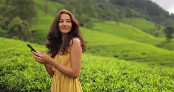 Traveler Woman With Smartphone During Her Travel on Famous Nature Landmark Tea Plantations in Sri alt
