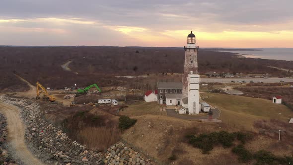 An aerial view of the Montauk lighthouse at sunset. The drone camera truck left and pan right around alt