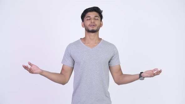 Young Happy Bearded Indian Man Relaxing with Eyes Closed alt