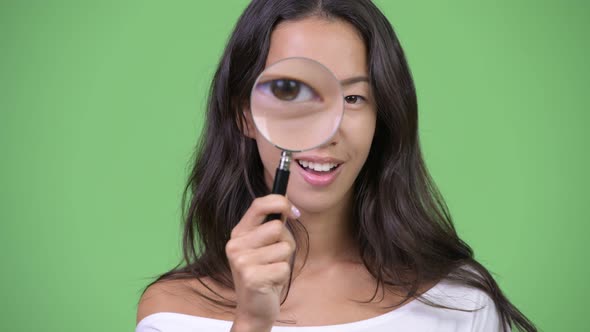 Young Happy Beautiful Multiethnic Woman Playing with Magnifying Glass
