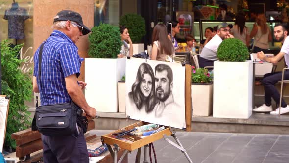Old Man Painter Artist Painting A Couple In The City Center Of Yerevan, Armenia