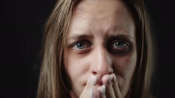 A Sad Beaten Up Woman with Tear in Eye and Bruises is Crying alt