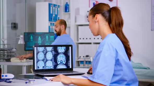 Doctor Assistant Analyzing Skull Brain Xray Tommography alt