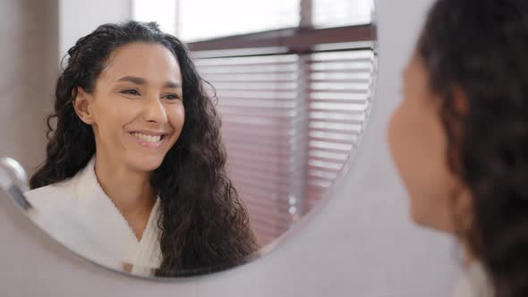 Pretty Confident Young Woman Stands in Bathroom Looks in Mirror Winks at Reflection Motivating for alt