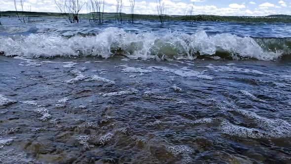 Waves with splashing water and blue skies and white clouds at Possum Kingdom Lake alt