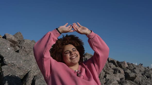 Beautiful Happy Smiling Plus Size African Black Woman Afro Hair in Pink Hoody Outside Enjoying