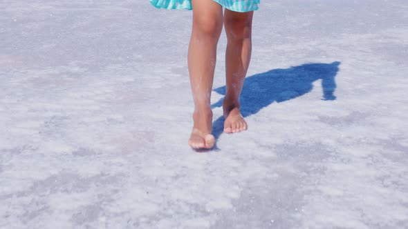 Little Faceless Girl Walks on Surface of Salt Lake alt