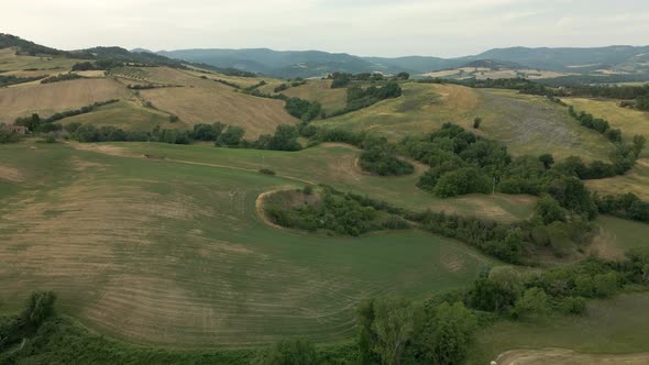 Aerial images of Tuscany in Italy cultivated fields summer, Crane view dry cultivated fields alt