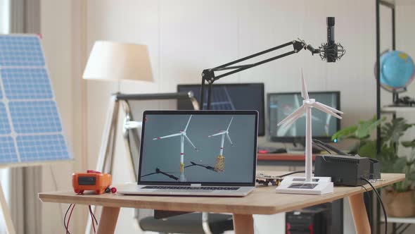 Laptop Showing Wind Turbine On The Table Next To The Solar Cell At The Office alt