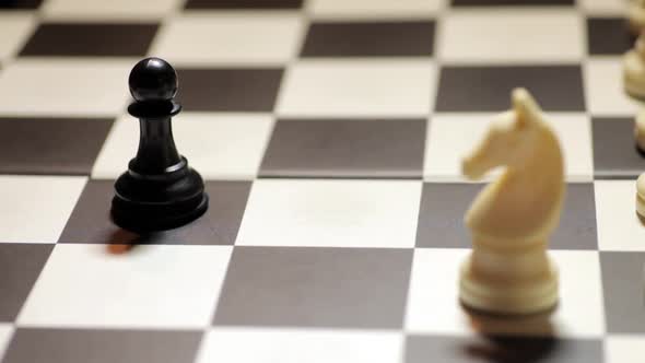 Chess match, with white knight capturing the black pawn