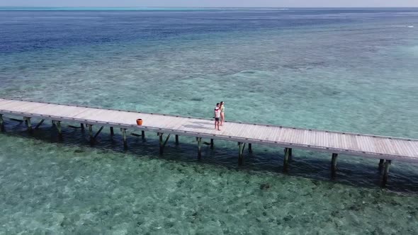 A Man and a Woman Couple Walking on Wooden Decking Bridge Holding Hands