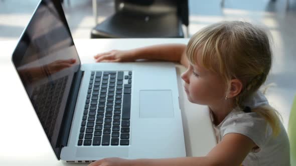Small Girl Playing On Laptop Computer