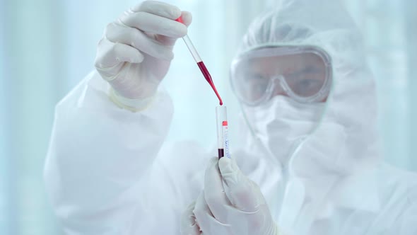 Doctor or Scientist drop sampling blood into tube to make a sampling test virus.