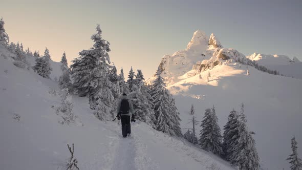 Adventure Photographer Hiking in High Altitude Mountain Environment During Winter Season
