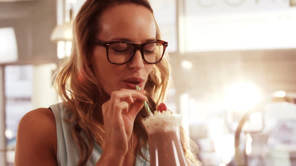 Smiling woman drinking milkshake alt