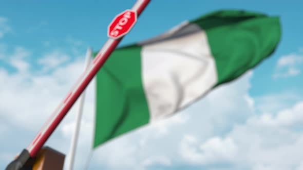 Closing Boom Barrier with Stop Sign Against the Nigerian Flag alt