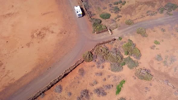 Big motorhome riding in desert during surfing vacations alt