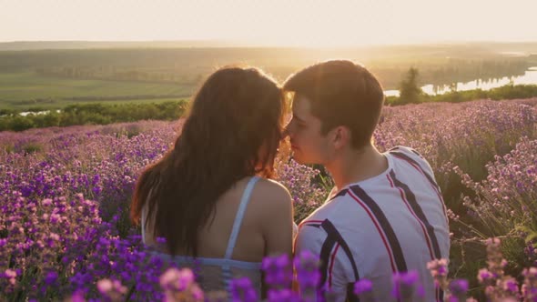 A Happy Married Young Couple in Love Sits in a Lavender Field