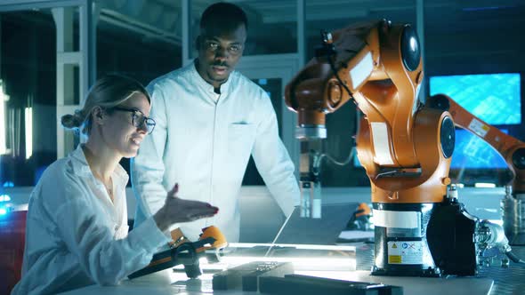 Two Scientists Are Watching a Functioning Robotic Arm alt
