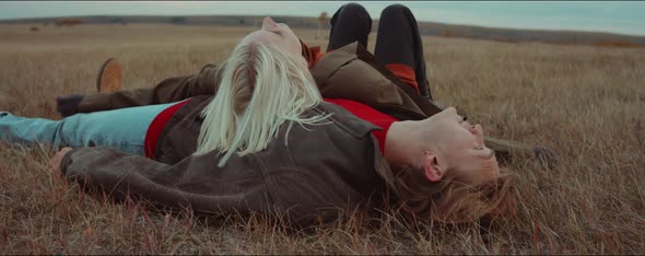 Woman Falling Down and Lying with Boyfriend on Autumn Field alt