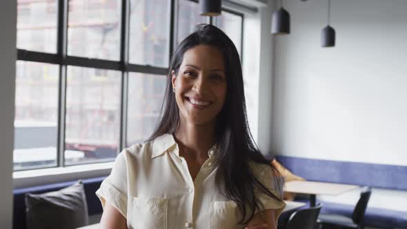 Portrait of happy mixed race businesswoman smiling to camera in office alt