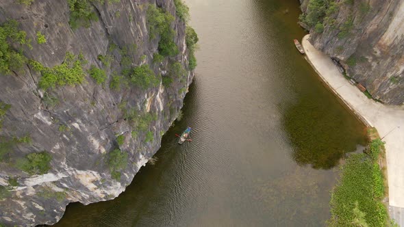 Aerial Shot of Beautiful Limestone Mountains with Passes Carved By a River in Ninh Binh Region a alt