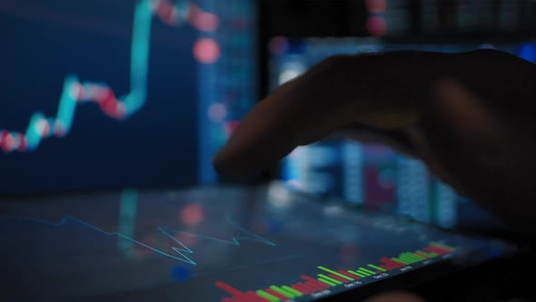 Trader Hand Analyzes the Stock Market on a Tablet alt