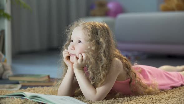 Dreamy Cute Girl Lying on Floor in Cozy Room at Home, Happy Child Thinking alt