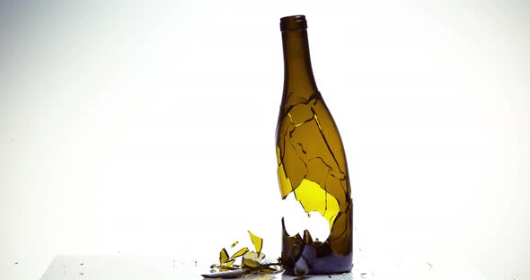 Bottle of White Wine Breaking and Splashing against White Background, Slow motion 4K