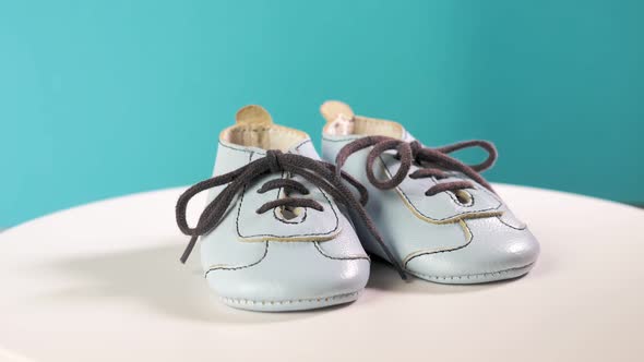 Small Baby Blue Boots Rotate on a Blue Background alt