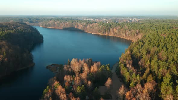 AERIAL: Panorama Look Above Beautiful and Calm Blue Lake and Green Pine Forest