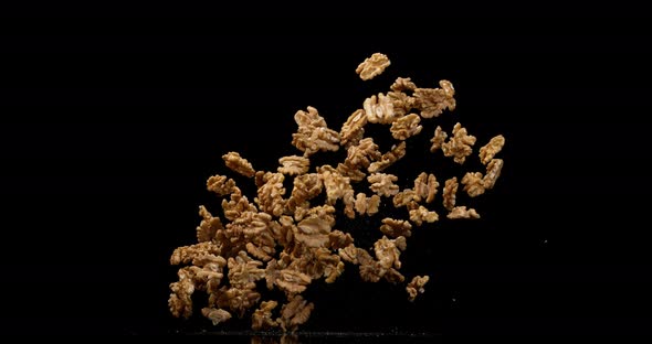 Walnut Kernels, juglans regia, Fruits falling against Black Background, Slow Motion 4K alt