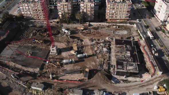 Tower crane, heavy machinery and workers at residential building under construction alt